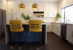 Kitchen with white cabinetry and blue island base