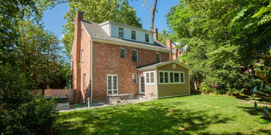 a brick house in the middle of a yard