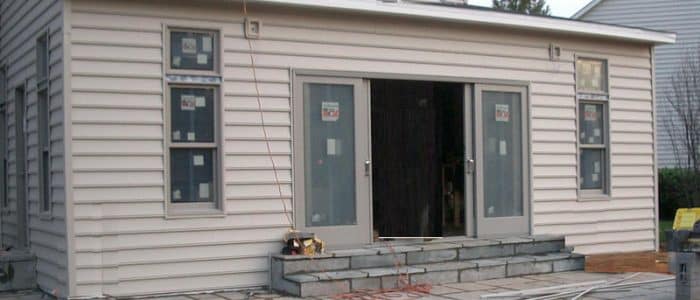 a small white house with a black door and windows