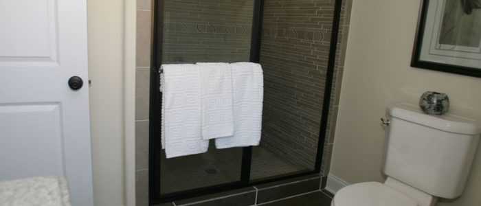 a bathroom with a toilet, shower and towel rack