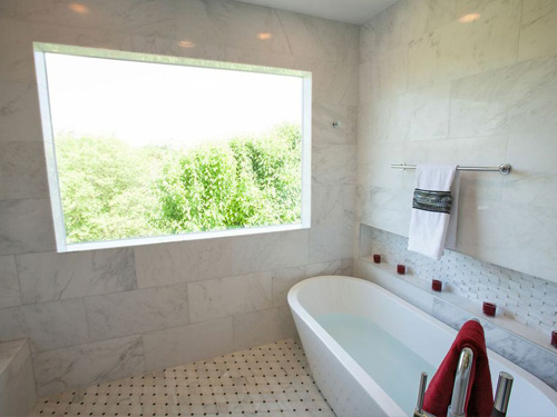 Remodeled bathroom with large window and soak-in tub