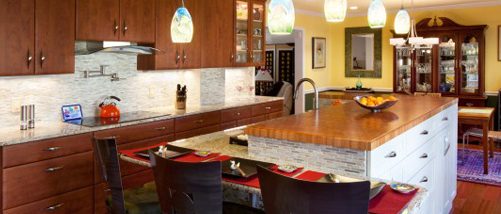 Remodeled kitchen with large island with built-in seating area and pendant lighting