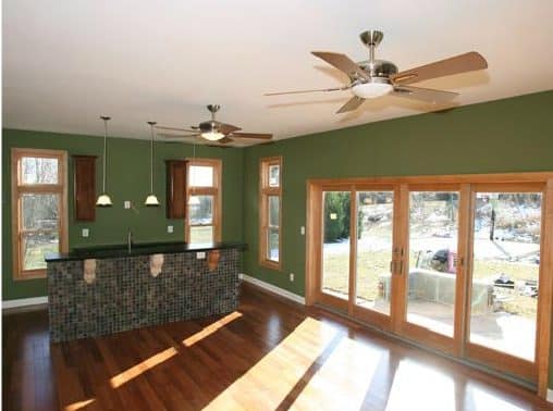 an empty room with wood floors and green walls