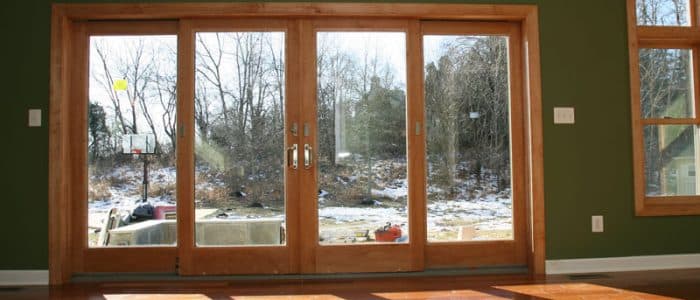 a living room with sliding glass doors and hardwood floors