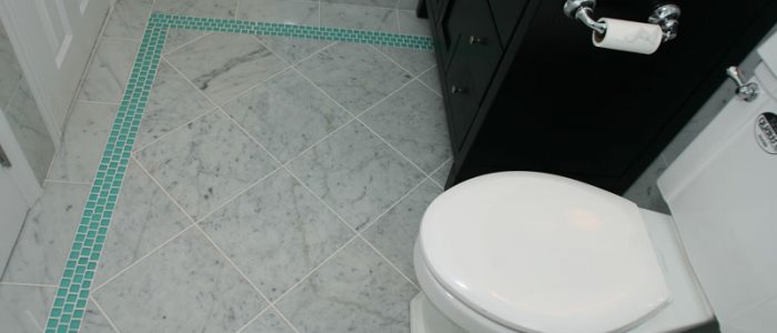 a white toilet sitting next to a black cabinet