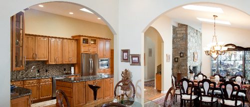 Remodeled large kitchen with arched entryways, wooden cabinetry, and multi-colored backsplash