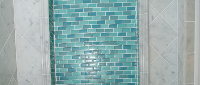 a bathroom with blue and white tiles on the wall