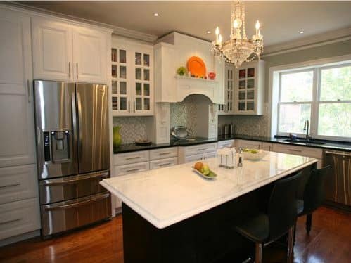 a large kitchen with white cabinets and black counter tops