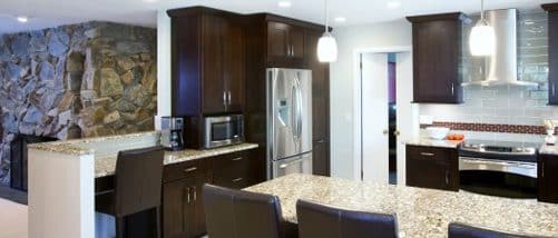 a modern kitchen with granite counter tops and dark wood cabinets