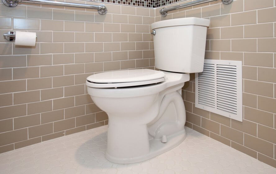 a white toilet sitting in a bathroom next to a heater