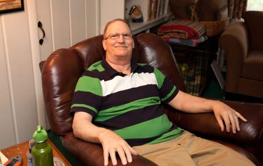 a man sitting in a chair with his legs crossed