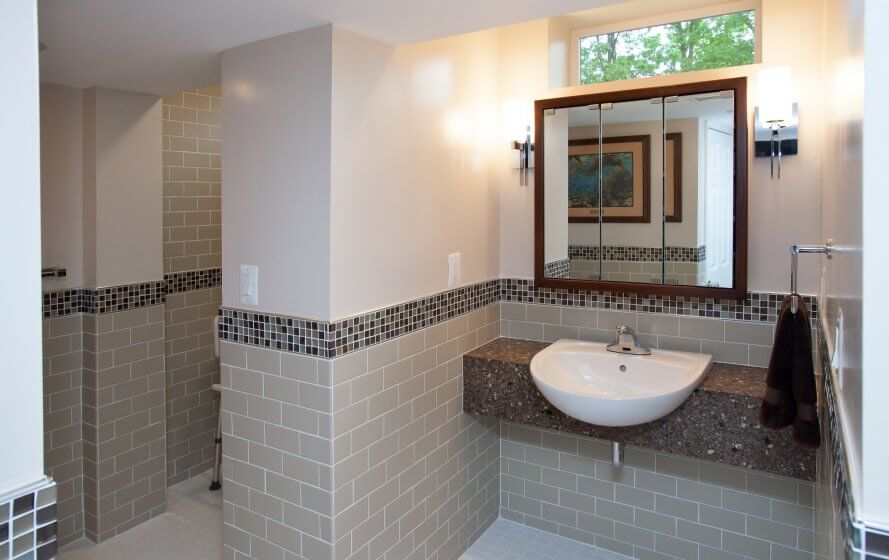 a white sink sitting under a bathroom mirror