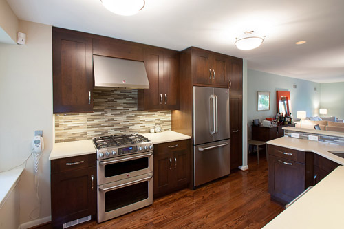 a kitchen with wood flooring and stainless steel appliances