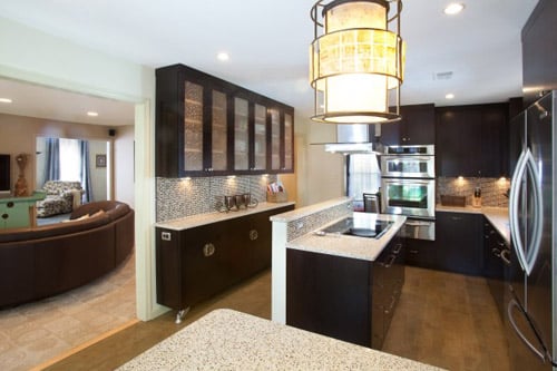 a kitchen with a stove top oven next to a living room