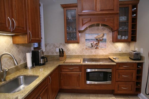 a kitchen with wooden cabinets and marble counter tops