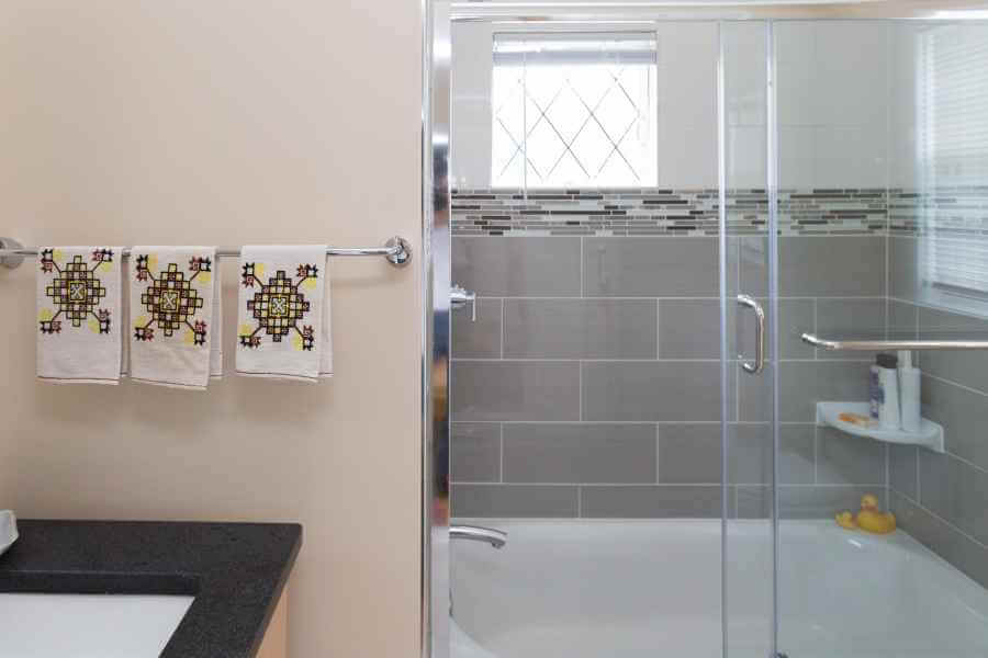 a bathroom with a sink, mirror and shower stall