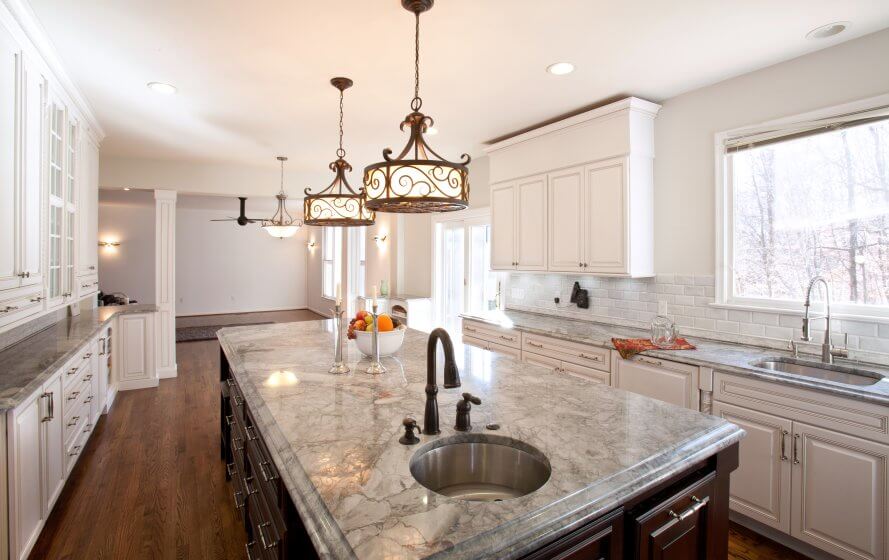 a kitchen with marble counter tops and white cabinets