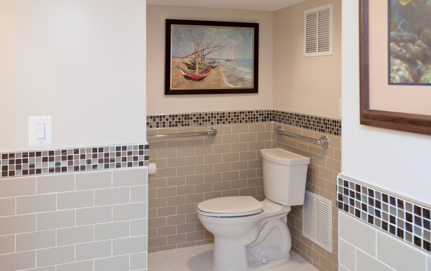 a bathroom with a toilet and a painting on the wall