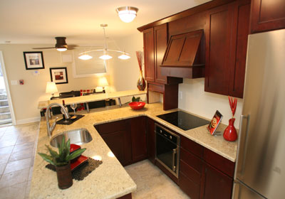 Renovated kitchen with dark wood-grain cabinets and light stone countertops.