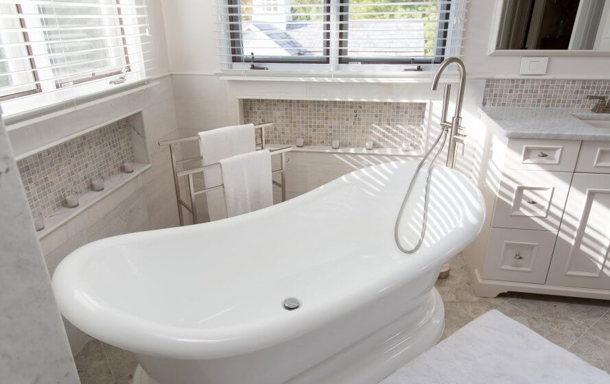 a large white bath tub sitting next to a window