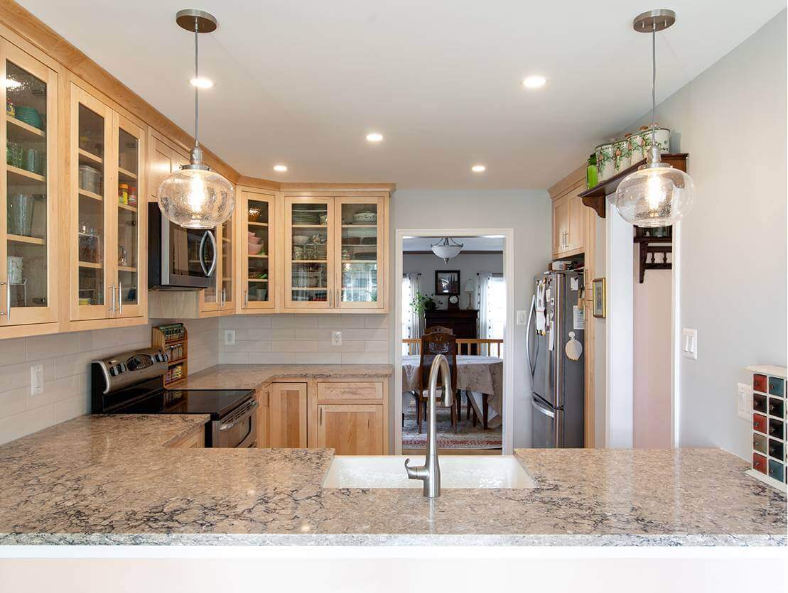 Renovated kitchen with granite countertops and glass cabinets.