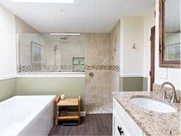 Renovated bahroom with a large shower, bath, and granite kitchen countertop.