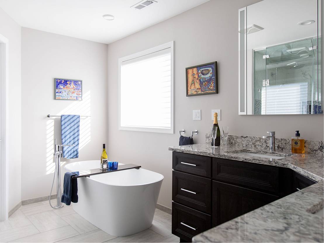 Home bathroom with white walls and a bathtub in the middle and a granite 