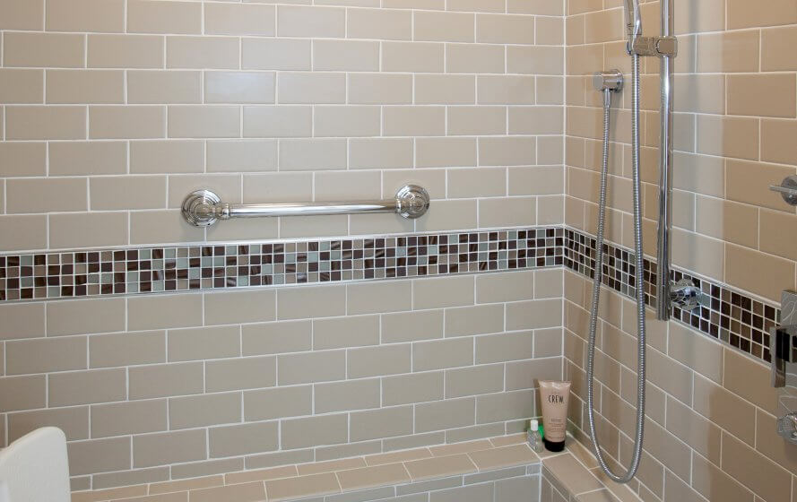 a bathroom with a shower and tiled walls