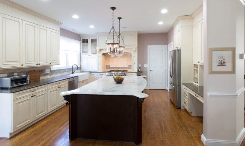 Kitchen remodel with white cabinetry and an island with a dark base