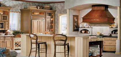 Poorly designed kitchen remodel with three different cabinet wood tones, too-big vent hood over stove, curved island.