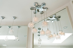 a bathroom with a mirror and lights hanging from the ceiling