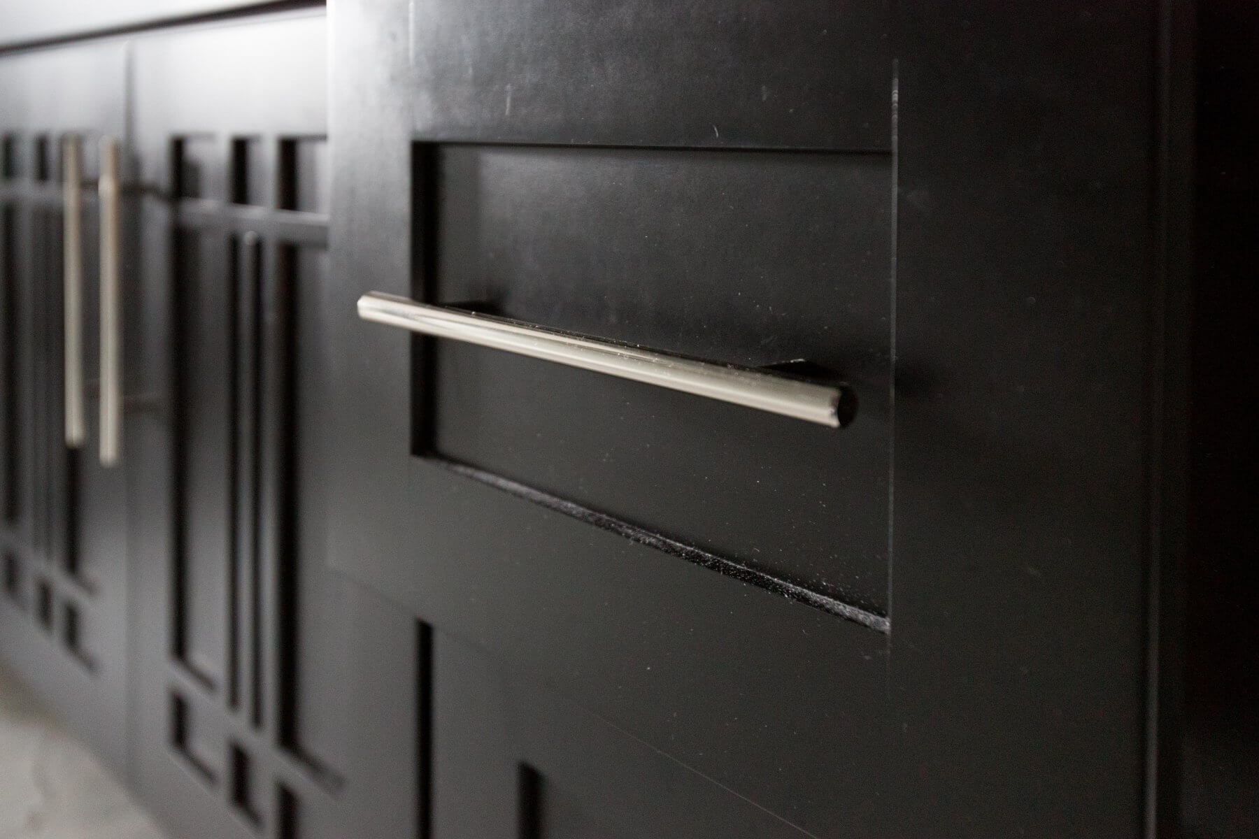 a close up of a door handle on a black cabinet