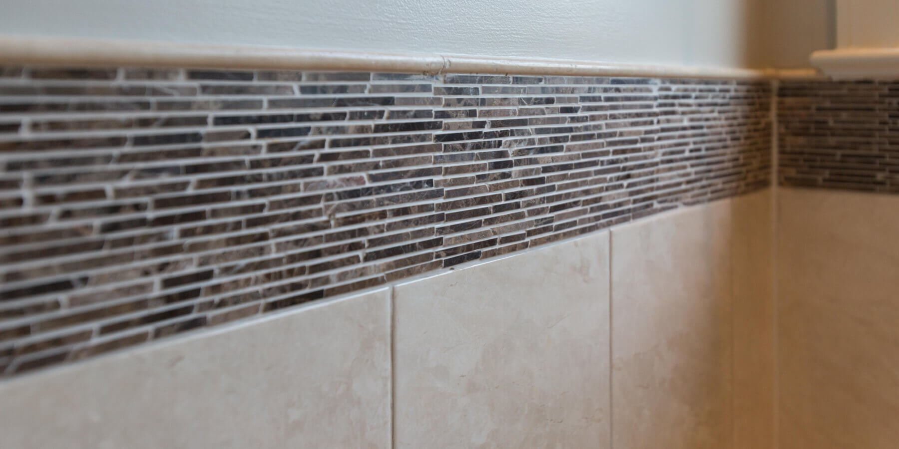 a close up of a tiled wall in a bathroom