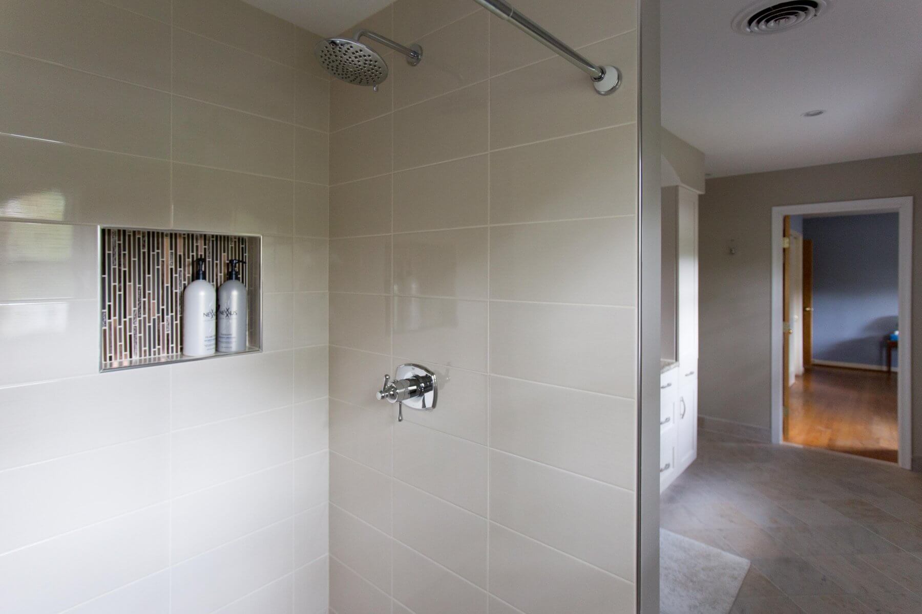 a bathroom with a shower head and tiled walls