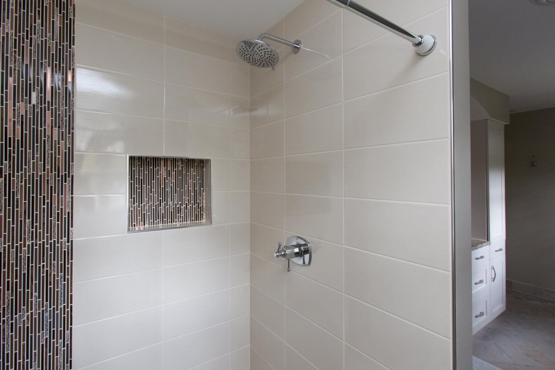 a bathroom with a walk in shower and tiled walls