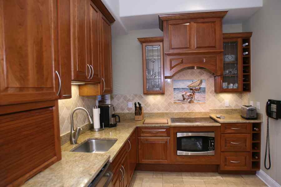 a kitchen with wooden cabinets and marble counter tops