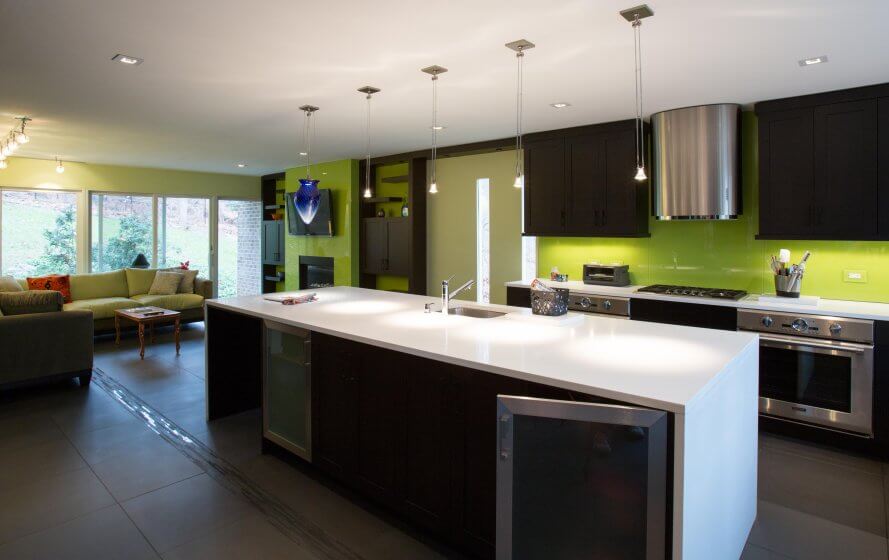 a modern kitchen with green walls and white counter tops