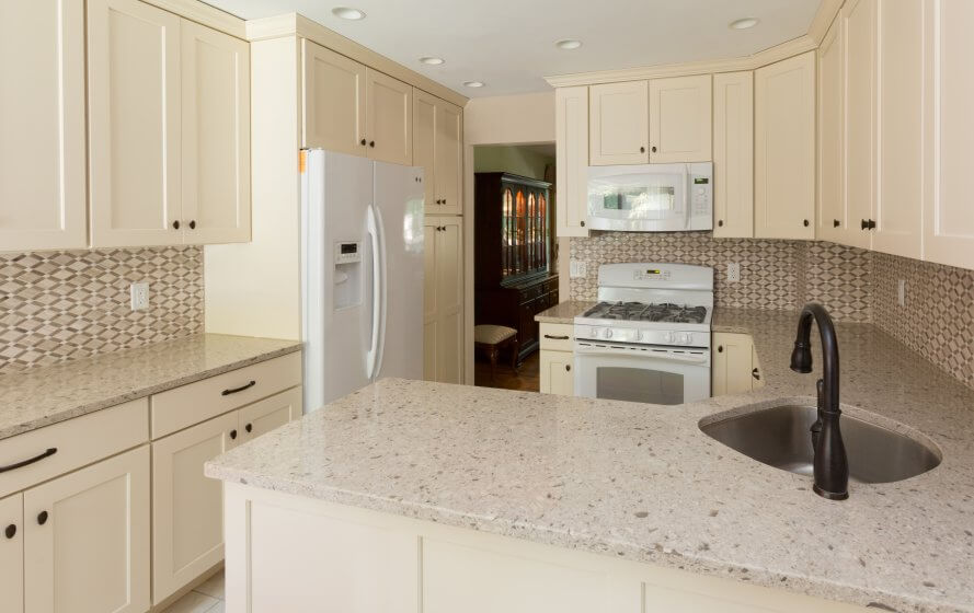 a kitchen with white cabinets and granite counter tops