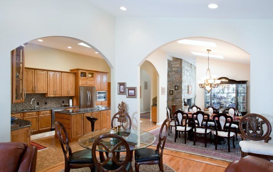 a dining room table and chairs in front of an archway