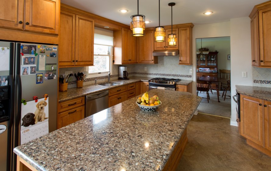 a kitchen with granite counter tops and wooden cabinets