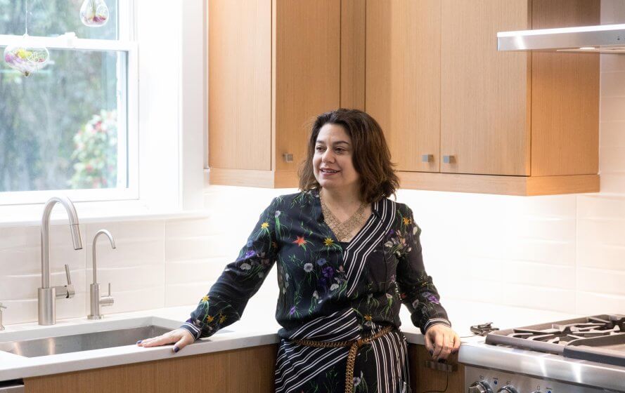 a woman standing in a kitchen next to a sink