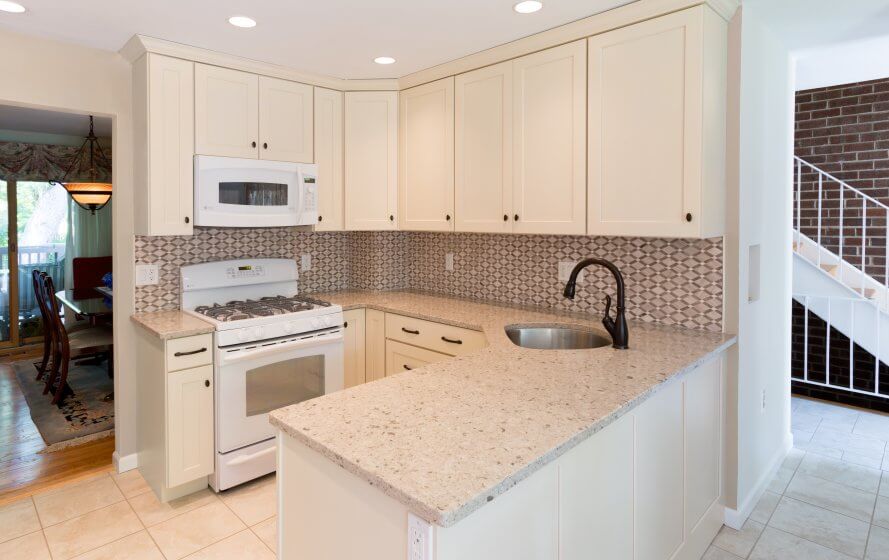 a kitchen with white cabinets and granite counter tops