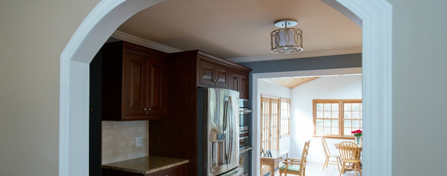 an archway leads into a kitchen and dining room