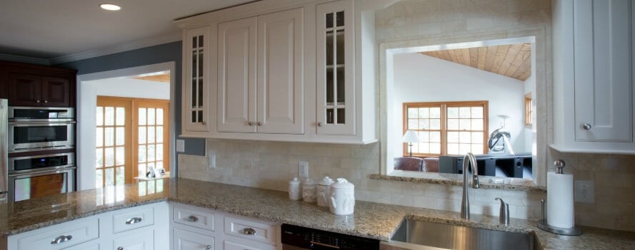 a kitchen with white cabinets and granite counter tops