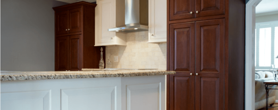 a kitchen with white cabinets and marble counter tops