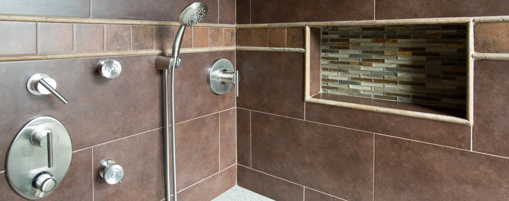 a bathroom with a shower head and hand held shower heads