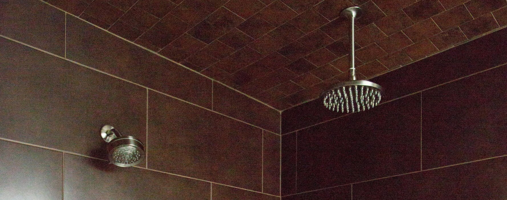 a bathroom with a shower head and tiled walls