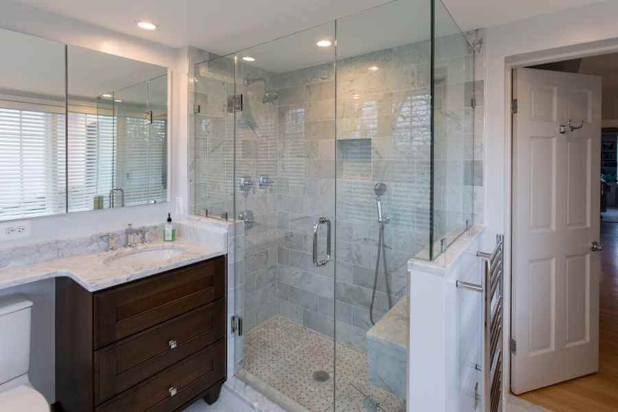 remodeled bathroom with glass shower with seating bench