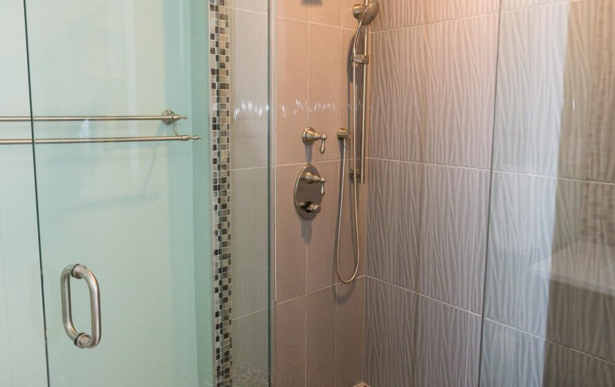 a bathroom with a glass shower door next to a toilet