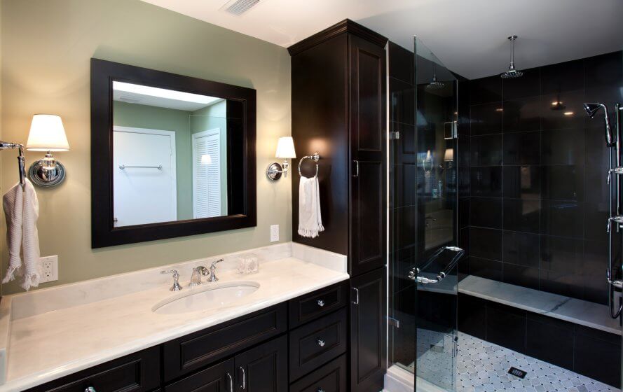 Remodeled bathroom with dark cabinetry and a walk-in shower with seating